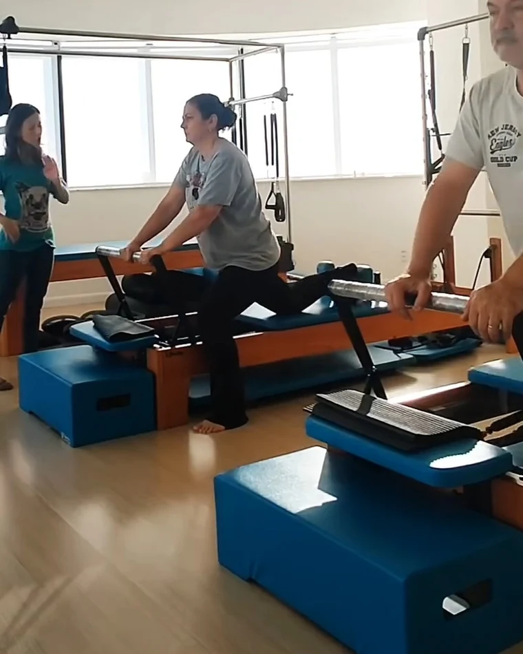 Karina acompanhando um aluno em exercício no reformer