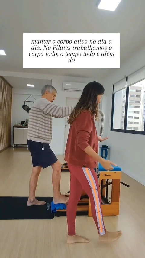 Karina acompanhando um aluno de 88 anos em exercício no estúdio