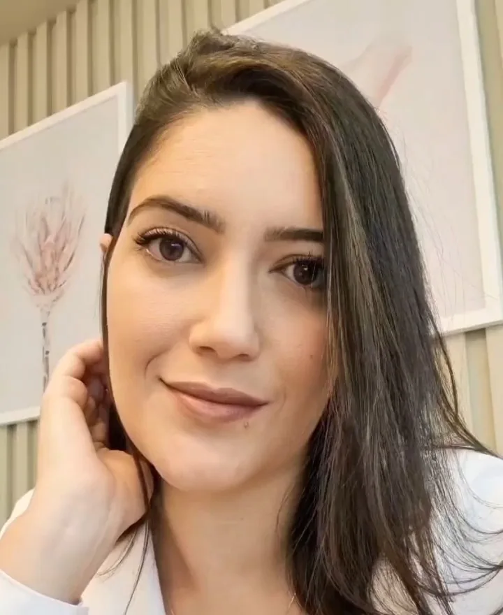 Retrato da Dra. Ana Vieira, de cabelo escuro e blazer branco, no consultório
