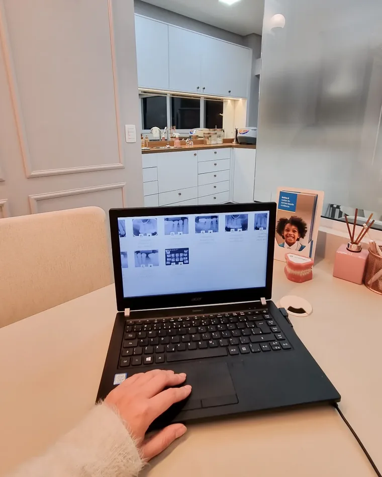 Notebook com fotografias e radiografias de uma documentação ortodôntica
