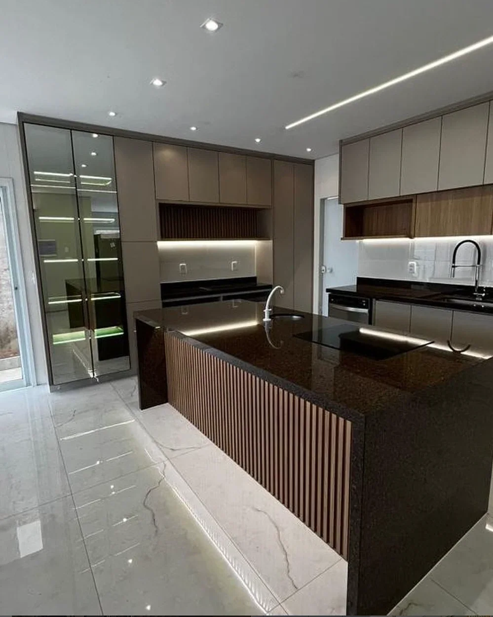 Cozinha planejada com ilha ripada, granito escuro e LED embutido